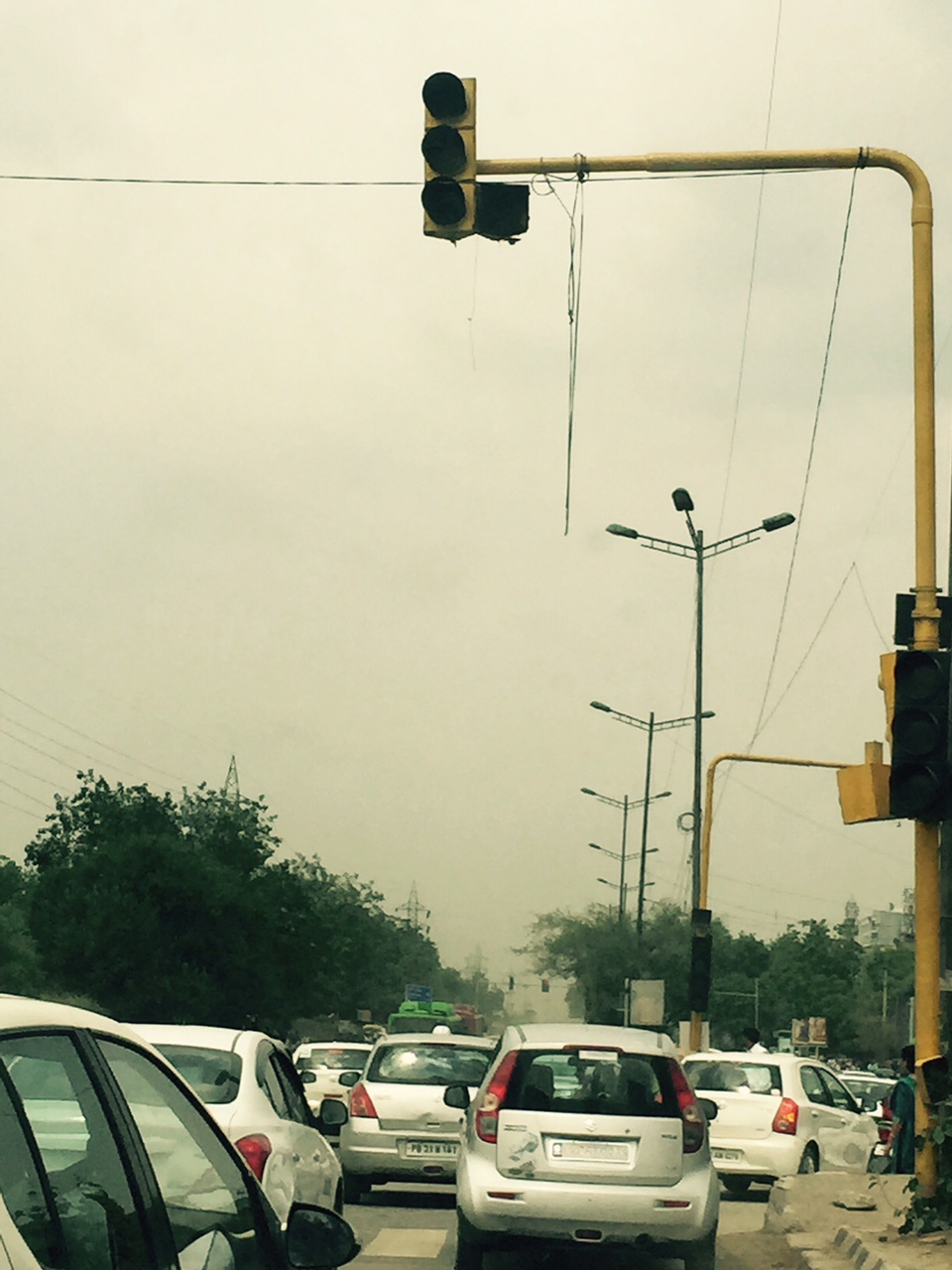 Traffic lights in Delhi are frequently non-functional;leading to noisy traffic snarls that significantly exacerbate air pollution; the sky at 10 am is not cloudy but full of dust.